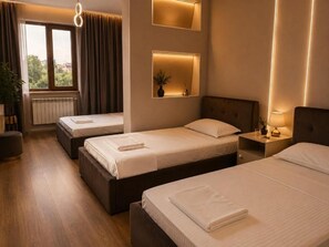 Une chambre d’hôtel avec deux lits, une fenêtre avec des rideaux, un radiateur et des lampes de chevet.
