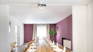 Un salón de conferencias con una larga mesa dispuesta para una reunión.
