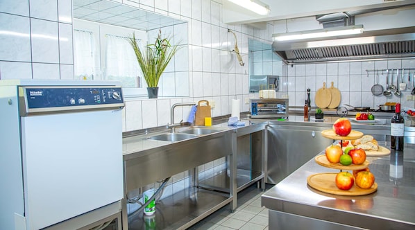 Una cocina moderna con electrodomésticos de acero inoxidable, horno empotrado y una variedad de utensilios de cocina.