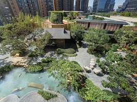 A rooftop garden with a koi pond, seating areas, and a view of surrounding buildings.