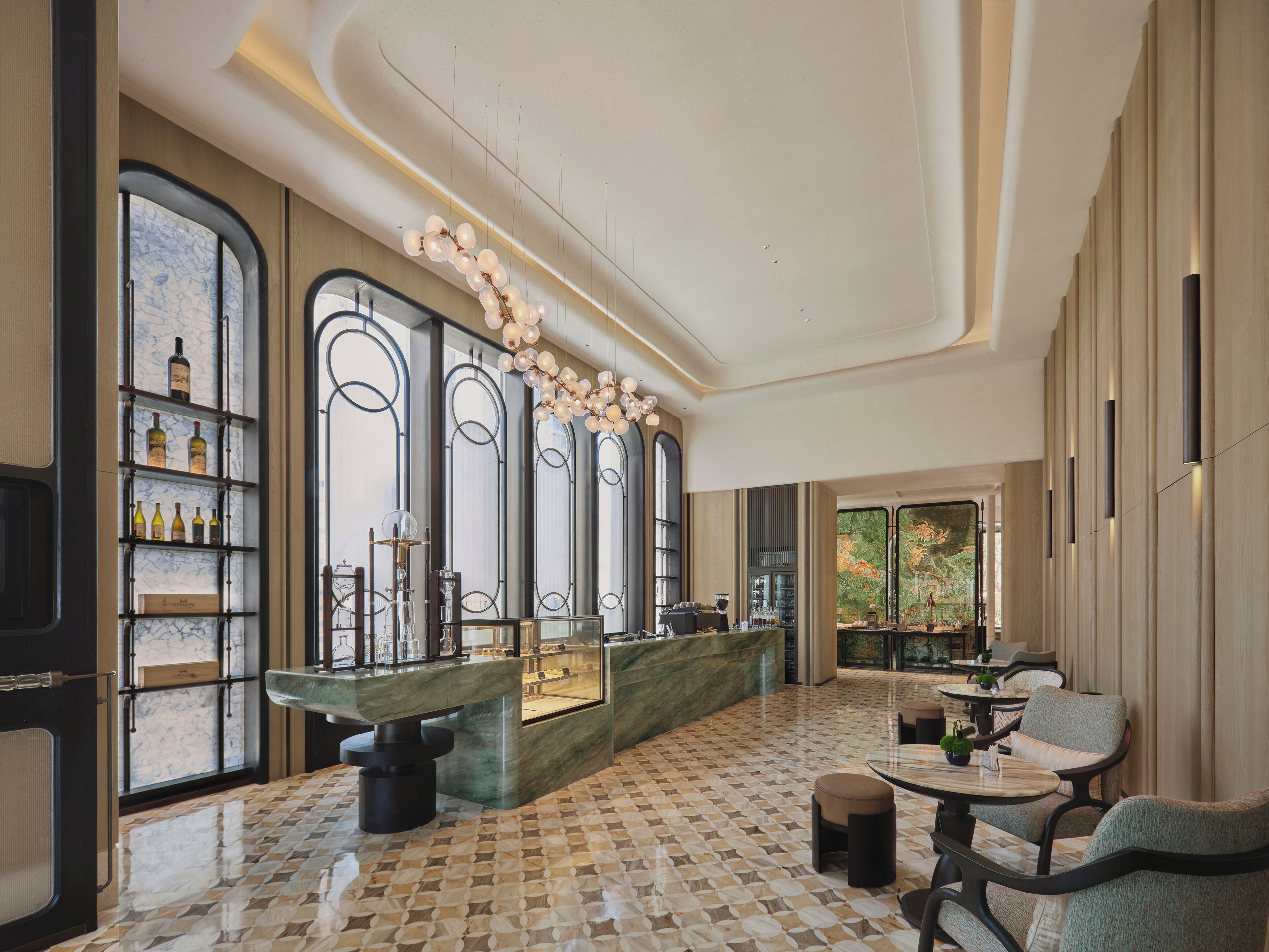 A spacious lobby with a marble floor, a reception desk, and a wine display.