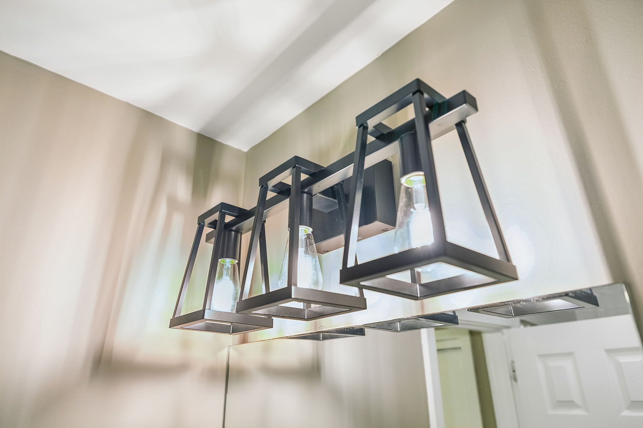 A modern ceiling light fixture with three rectangular lanterns.