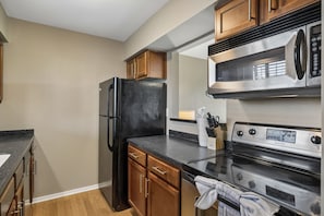 Eine moderne Küche mit Kühlschrank, Backofen und Mikrowelle aus Edelstahl.
