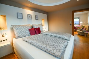 Ein modernes Schlafzimmer mit einem großen Bett, Nachttischen und Wandleuchten.