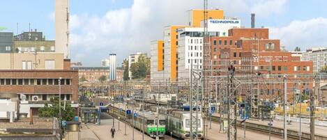 A train station with multiple tracks and a prominent building labeled 'TECHNOPOLIS'.