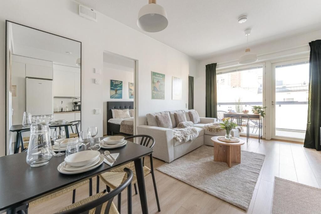 Una sala de estar moderna con comedor, sofá, mesa de centro y vista al exterior.