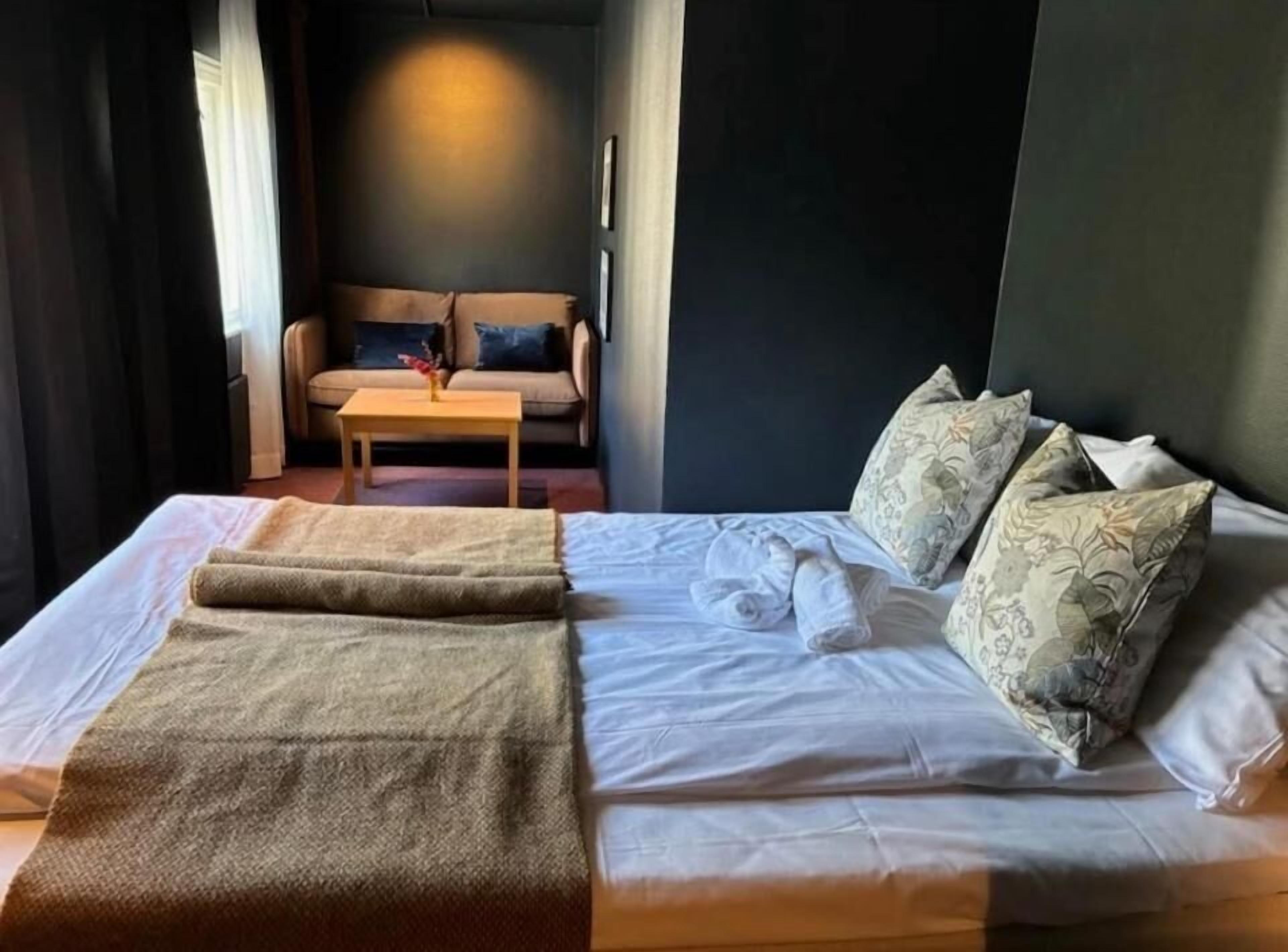 Una habitación de hotel con una cama, un sofá y una mesita.