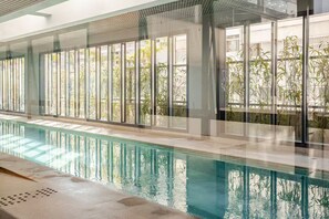 An indoor swimming pool with clear glass walls, allowing views of the outside. - Comfort and sophistication next to Shopping Frei Caneca and 2 minutes from Sírio-Libanês Hospital. (São Paulo)