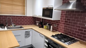 A modern kitchen with a gas stove, oven, and a stainless steel range hood. - Stylish two bedrooms apartment between King's Cross St Pancras and Russel Square (London)