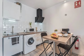 A compact kitchen with a washing machine, microwave, and coffee machine. - Modern Studio with Pool in Arona - Ideal for Couples. (Arona)