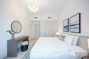 Un dormitorio moderno con una cama grande, mesitas de noche, un espejo y obras de arte en la pared.