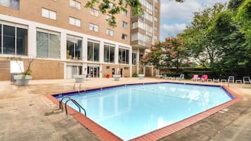 A rectangular swimming pool with a tiled edge, surrounded by a concrete deck.