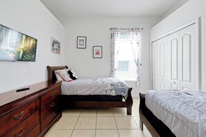 A bedroom with a bed, a dresser, a TV, and framed pictures on the wall. - 4BR Golf Villa w/ Pool, Near Disney & Beaches (Davenport)