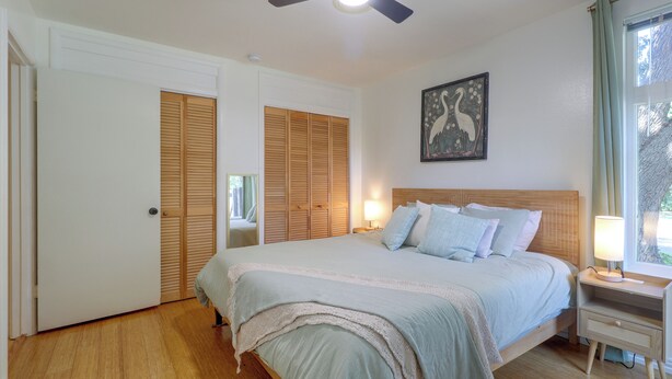 A bedroom with a bed, bedside lamps, a ceiling fan, and a window with curtains. - Mid-term Stay in Austin! Family Home w/ Backyard (Austin)
