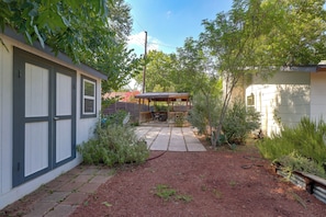 Ein Garten mit Terrasse, Holzdeck und umzäunter Fläche.
