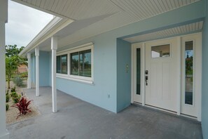 Een gebouw met een overdekte veranda, een deur en een raam.
