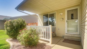 A house with a front porch, a small garden, and a door with a glass panel.