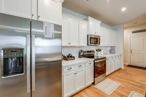 A modern kitchen with white cabinetry, stainless steel appliances, and a water dispenser. - May River Fun! Home 9 Mi to Hilton Head Island (Bluffton)