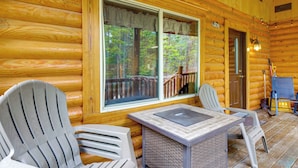 A log cabin with two Adirondack chairs, a table, and a door leading to a covered porch. - Pool Table & Peaceful Porch: Fairplay Retreat (Fairplay)