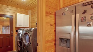 A compact kitchen with wooden walls, a stainless steel refrigerator, and a washing machine. - Mountain Top Lodge With Amazing Vista (Jasper)