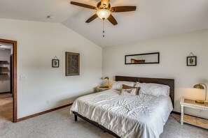 A bedroom with a bed, a nightstand, a desk, a ceiling fan, and a mirror on the wall. - Private Yard w/ Patio! Rapid City Escape (Rapid City)