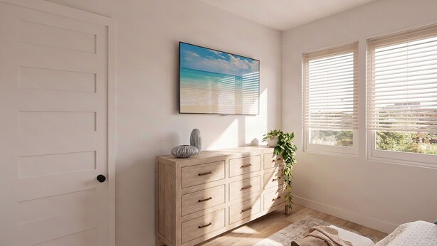Ein Zimmer mit einem Holzkasten, einem gerahmten Bild und einem Fenster mit Jalousien.