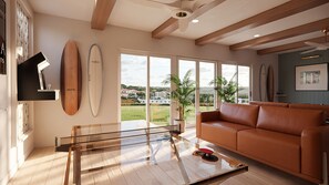 Ein modernes Wohnzimmer mit einem Glastisch, einem Ledersofa und Blick auf eine grüne Landschaft durch große Fenster.
