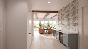 Eine moderne Küche mit Holzboden, einem Essbereich mit Tisch und Stühlen sowie Blick durch große Fenster.