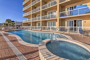 A hotel with a swimming pool, multiple balconies, and a brick pathway. - Unwind Poolside, Walk to Sand! 18th-floor PCB Unit (Panama City Beach)