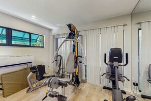 A modern gym with various exercise equipment, including a stationary bike, a rowing machine, and a treadmill. - < 1 Mi to Beach! Top-floor Naples Retreat w/ Pool (Naples)