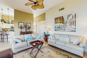 A living room with two sofas, a coffee table, and a painting on the wall. - < 1 Mi to Beach! Top-floor Naples Retreat w/ Pool (Naples)