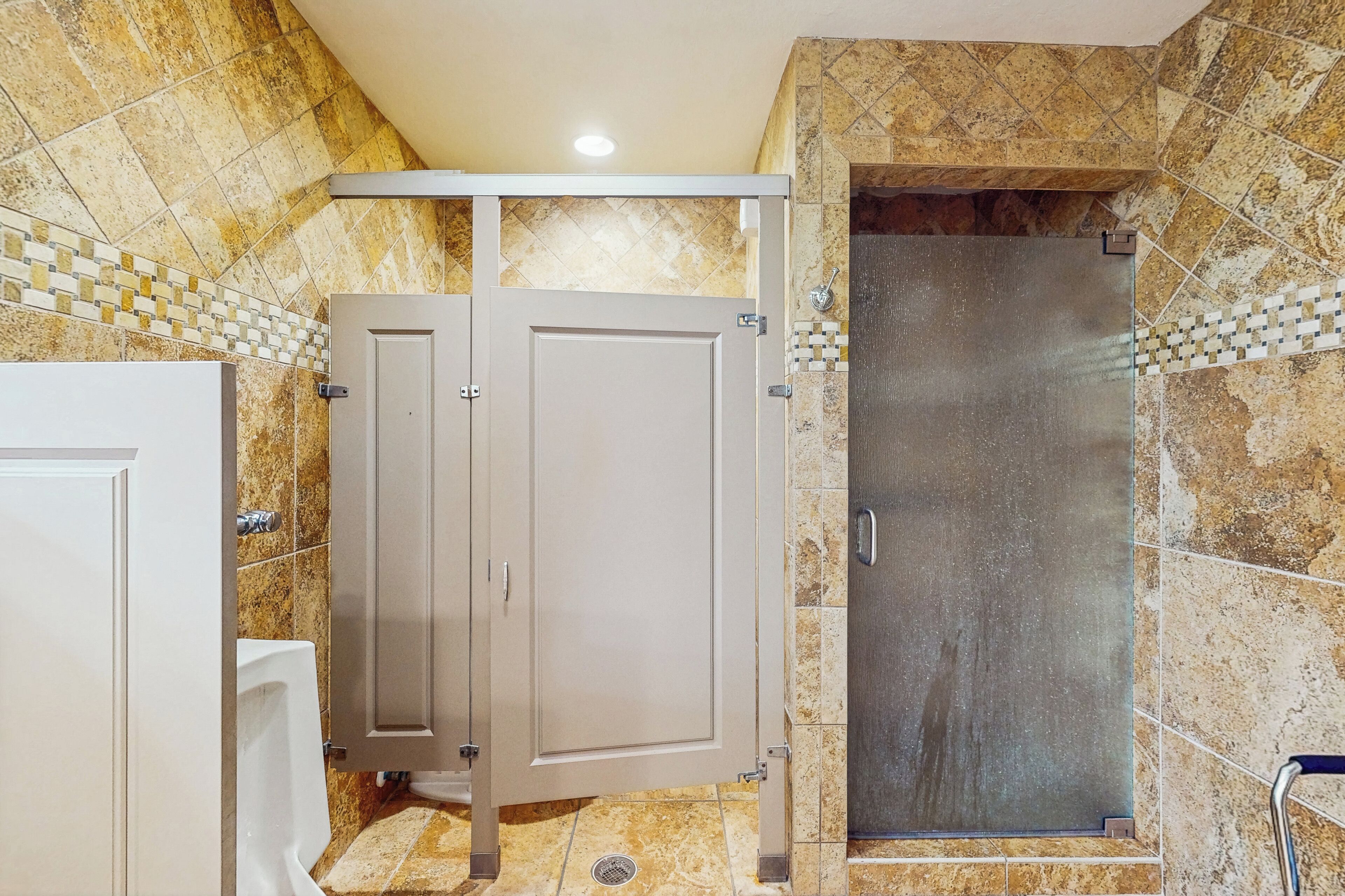 A bathroom with a shower, a toilet, and a sink.