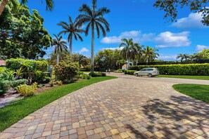 A paved driveway leading to a building with a car parked nearby. - < 1 Mi to Beach! Top-floor Naples Retreat w/ Pool (Naples)