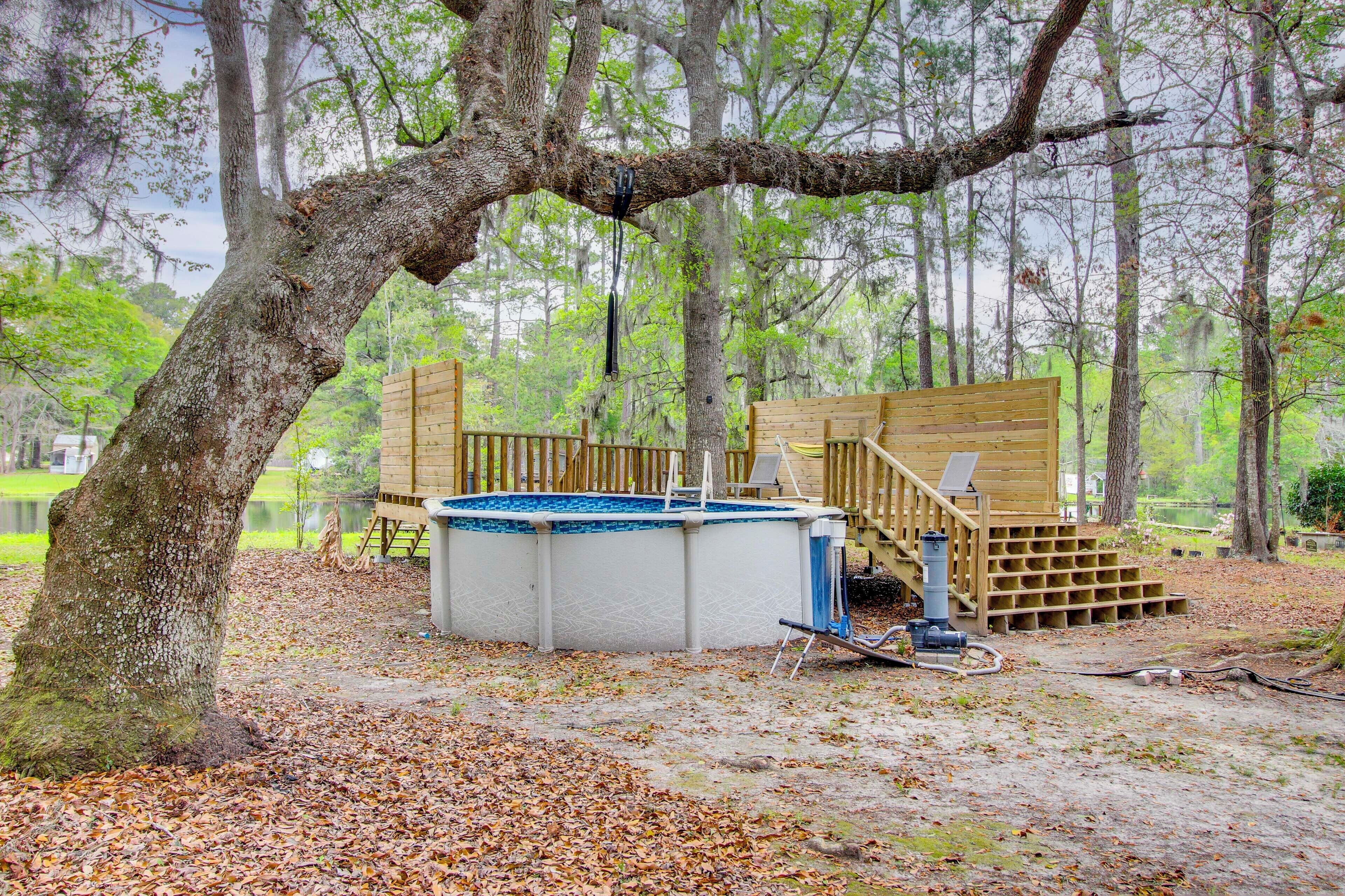 A wooden deck with a hot tub, surrounded by trees and a natural setting.