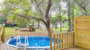 A wooden deck with a small swimming pool, surrounded by trees and a wooden fence. - Pool & Fishing at Lakefront Midway Retreat (Midway)