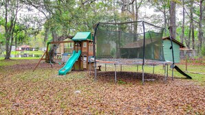 A playground with a slide, swings, and a trampoline. - Pool & Fishing at Lakefront Midway Retreat (Midway)