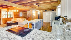 A log cabin interior with a living room, kitchen, and a dining area. - Pool & Fishing at Lakefront Midway Retreat (Midway)
