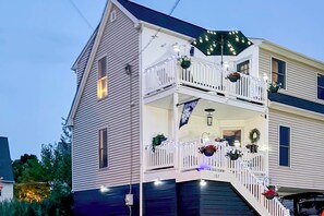 A two-story house with a balcony, decorated with lights and wreaths. - Walk to Bowers Beach! Peaceful Coastal Retreat (Frederica)