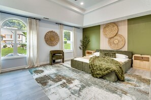 A bedroom with a bed, nightstands, a chair, a large window, and a view of the outside. - 4 Mi to Six Flags! Group Retreat in Mableton (Mableton)