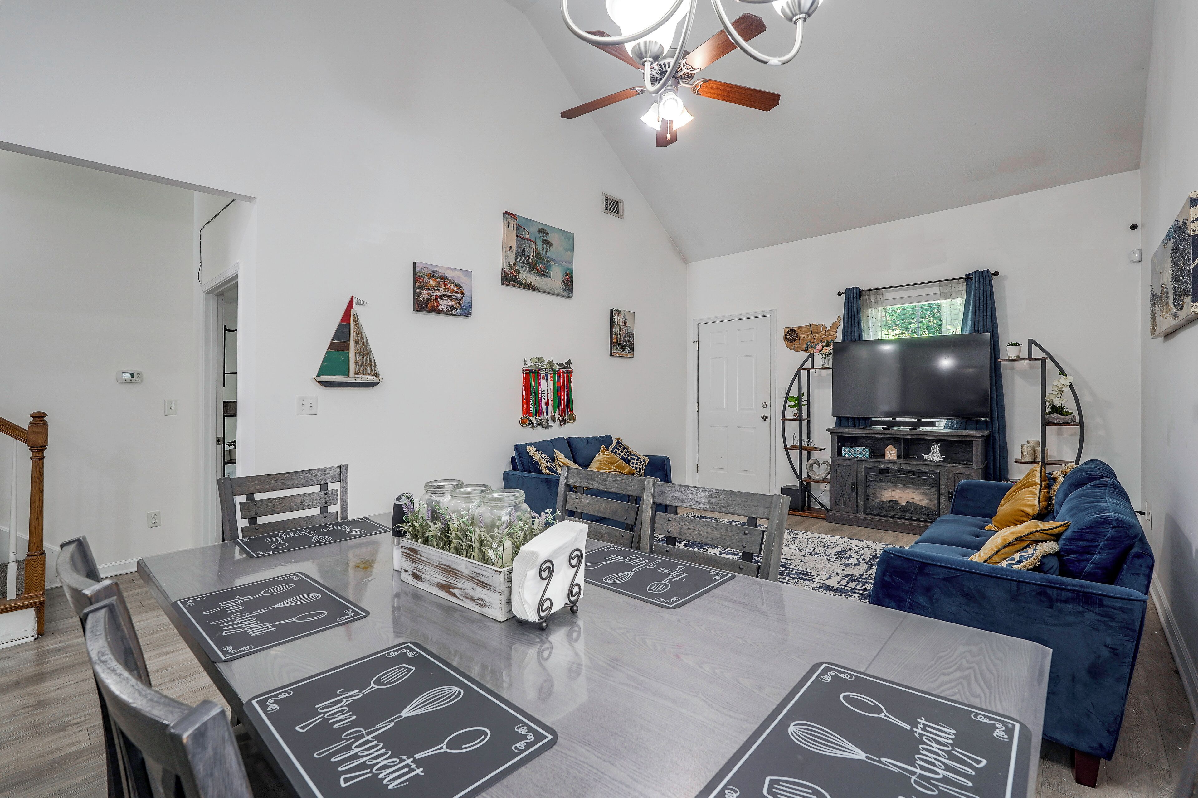 A modern living room with a dining area, a fireplace, and a television.