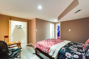 A bedroom with a bed, a desk, and a chair. There is a door leading to another room. - Hike, Golf & Relax! Basement Apt in Hagerstown (Hagerstown)
