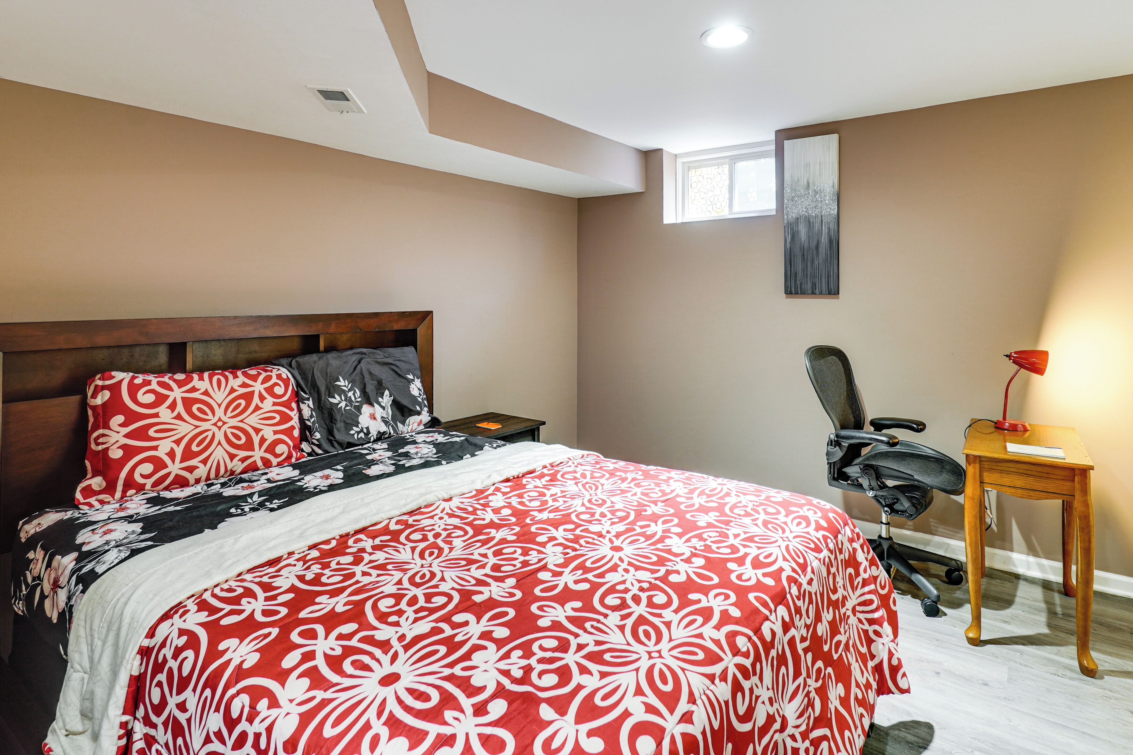 Un dormitorio con una cama grande, un escritorio y una silla.
