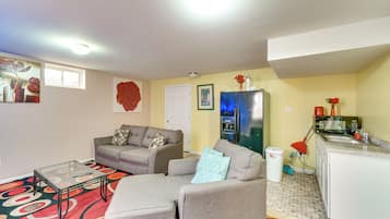Un espacio habitable pequeño con sofá, una mesita de centro y una kitchenette.