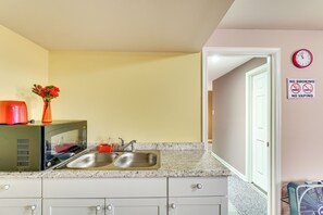 A kitchen with a double sink, a microwave, and a clock on the wall. - Hike, Golf & Relax! Basement Apt in Hagerstown (Hagerstown)