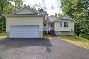 A two-story residential building with a garage, a covered porch, and a satellite dish. - Poconos Getaway w/ Private Ski Slope & Pool Access (East Stroudsburg)
