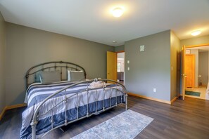 A bedroom with a metal-framed bed, a wooden door, and a view into another room. - Poconos Getaway w/ Private Ski Slope & Pool Access (East Stroudsburg)