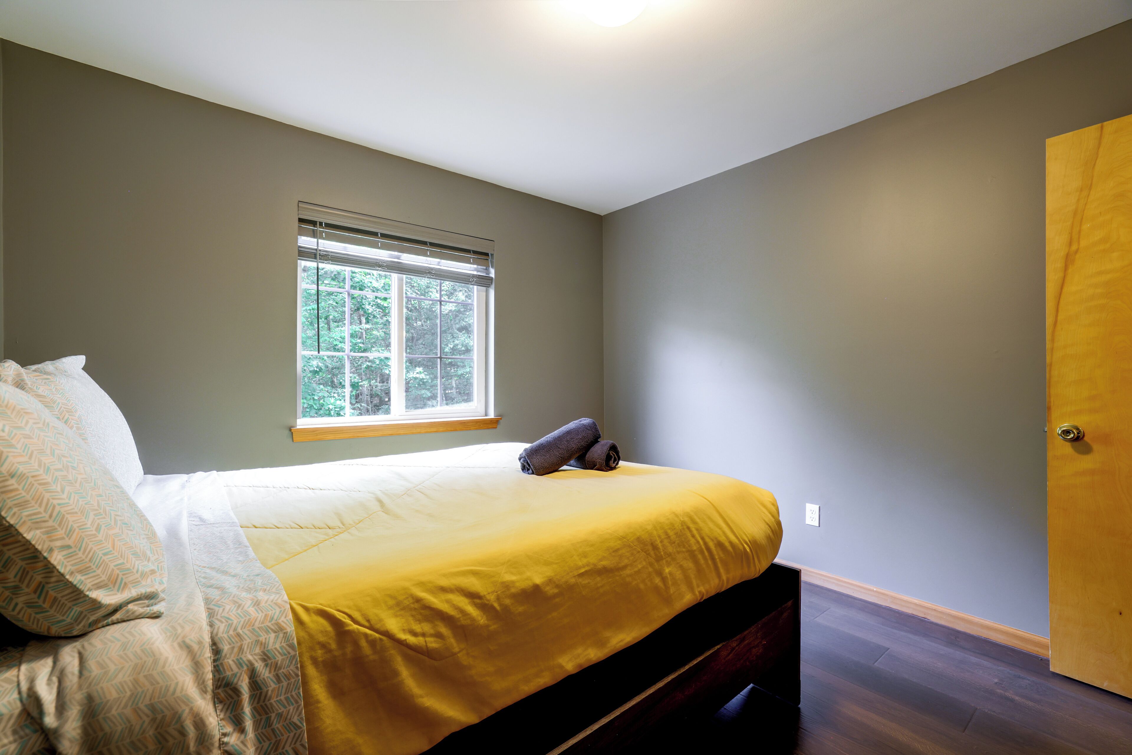 Un dormitorio con cama, ventana y puerta.