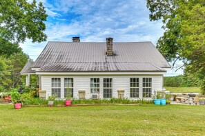 A single-story house with a gabled roof, large windows, and a front porch.