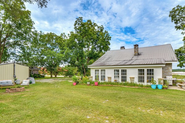 A single-story house with a sloped roof, a stone chimney, and a front porch.