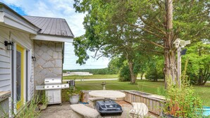 A backyard with a barbecue grill, outdoor seating, and a view of the surrounding landscape. - Hike, Fish & Explore! Family Getaway in Elberton (Elberton)